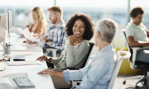 smiling woman talks to a coworker