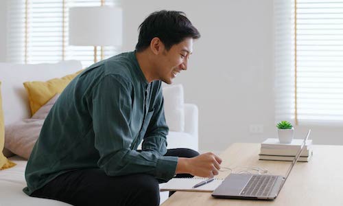 smiling man types on a computer