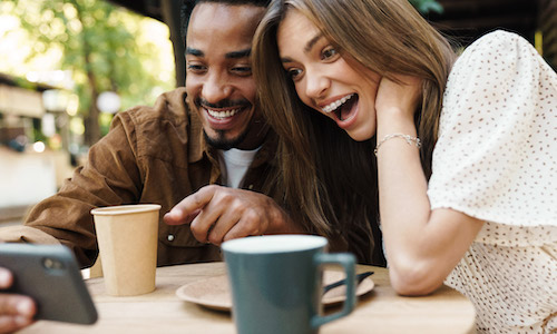 smilng man and woman looking at a phone