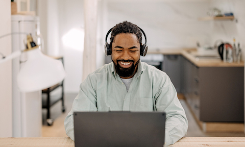 smiling man working on a laptop