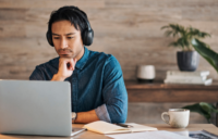 man wearing headphones working on laptop